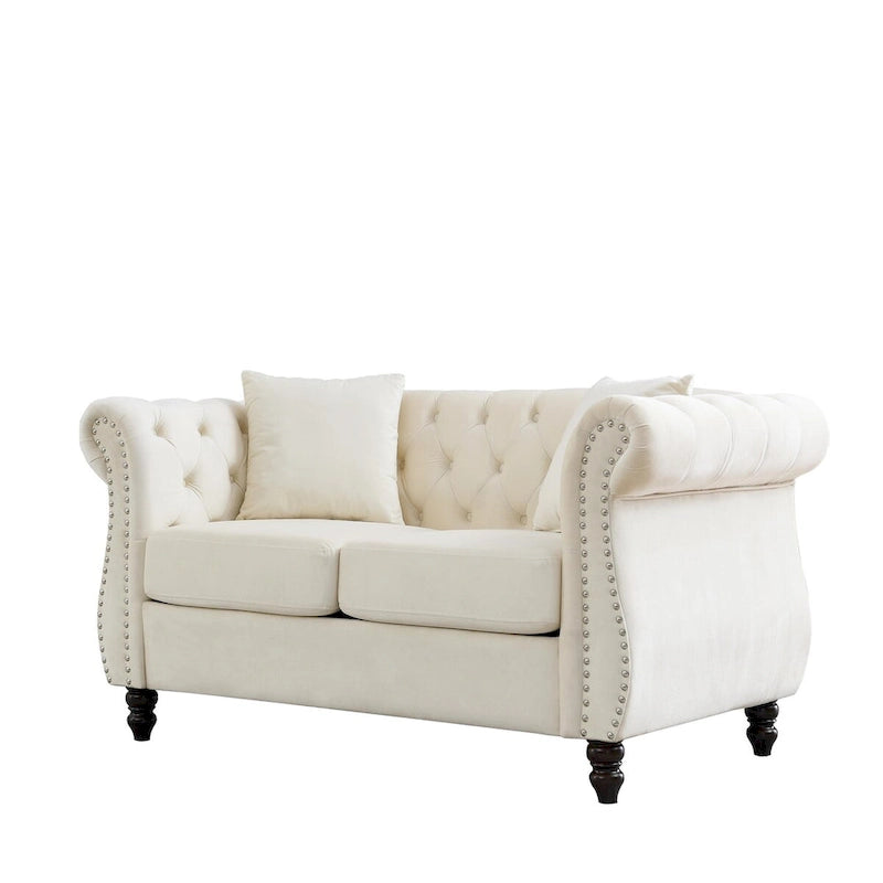 Canapé deux places Chesterfield en velours beige, accoudoirs roulés, garniture cloutée
